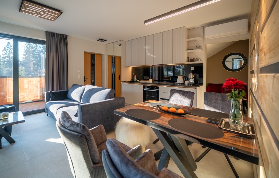 Wnętrze apartamentu - sofa, stół i aneks kuchenny