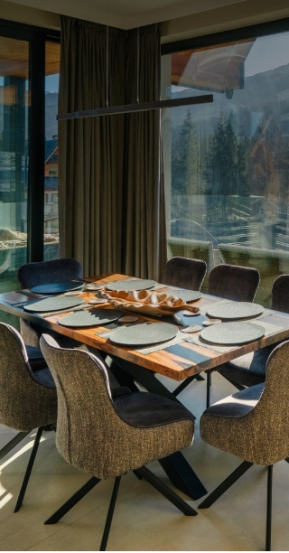 Duży stól z krzesłami w jadalni z widokiem na góry